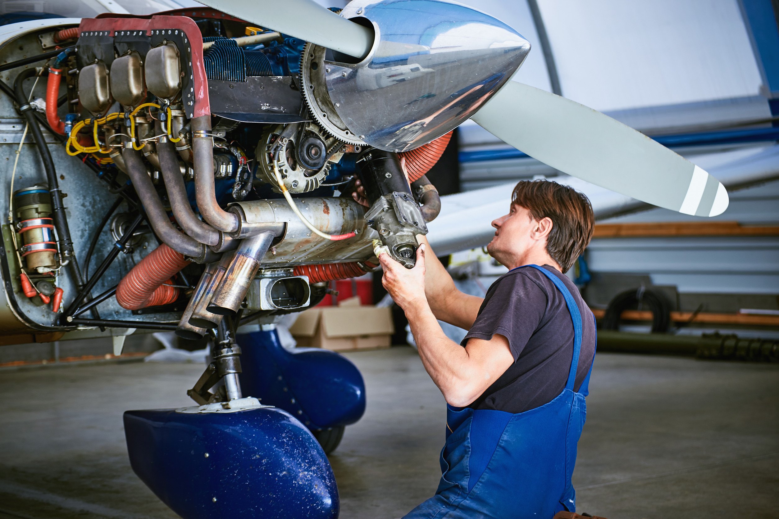 a mechanic working on the engine of a propeller plane