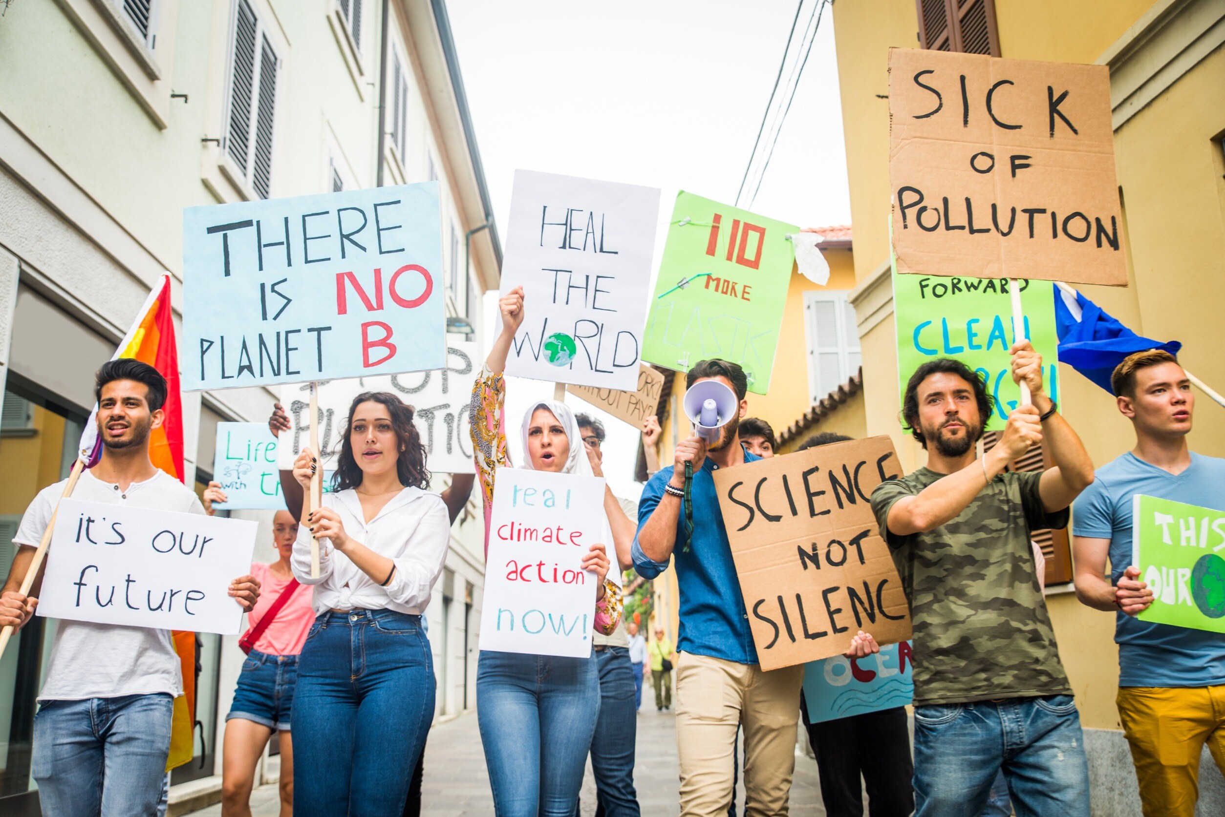 Group of activists is protesting outdoors - Young people with placards in the street