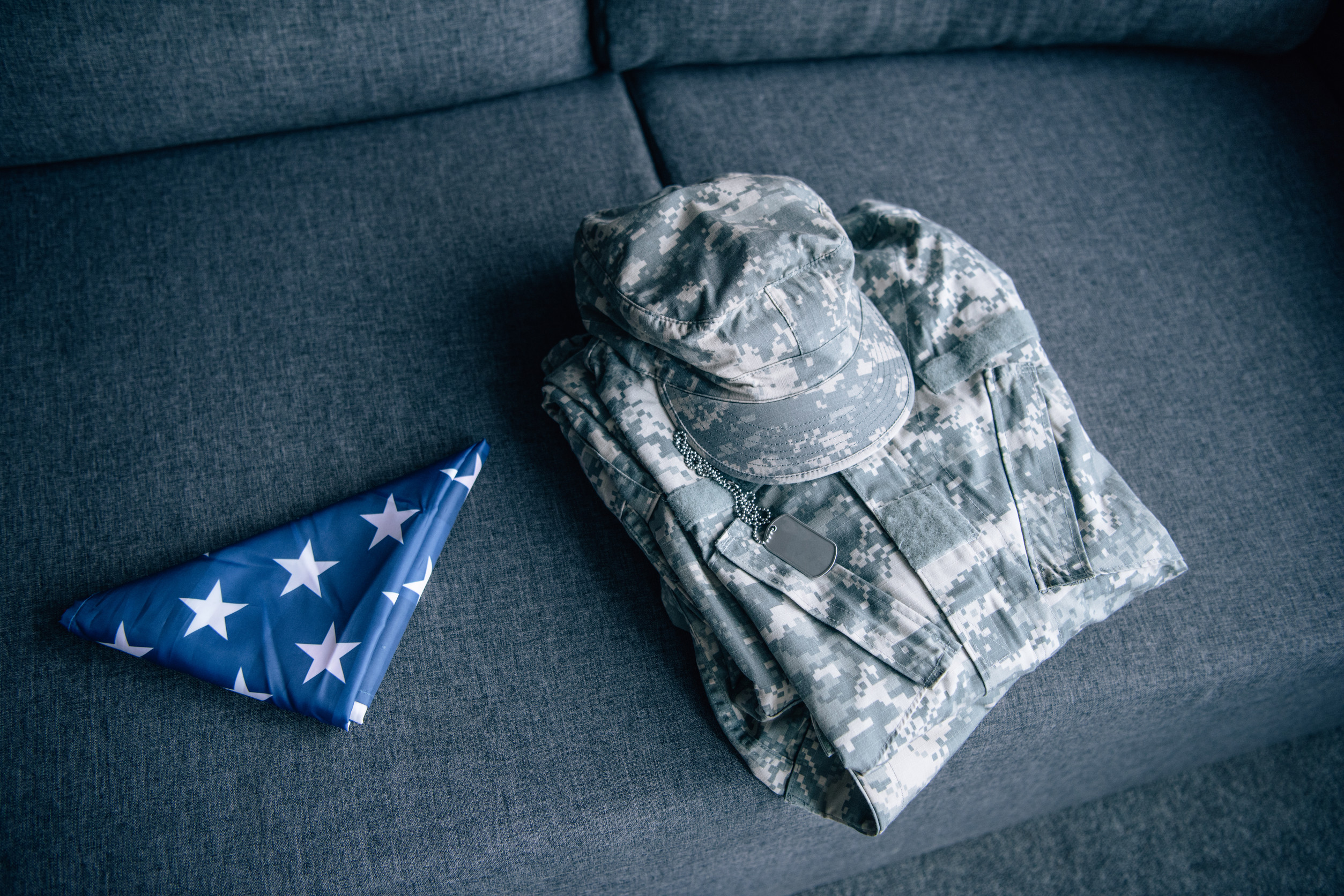 military clothing and folded american flag on couch