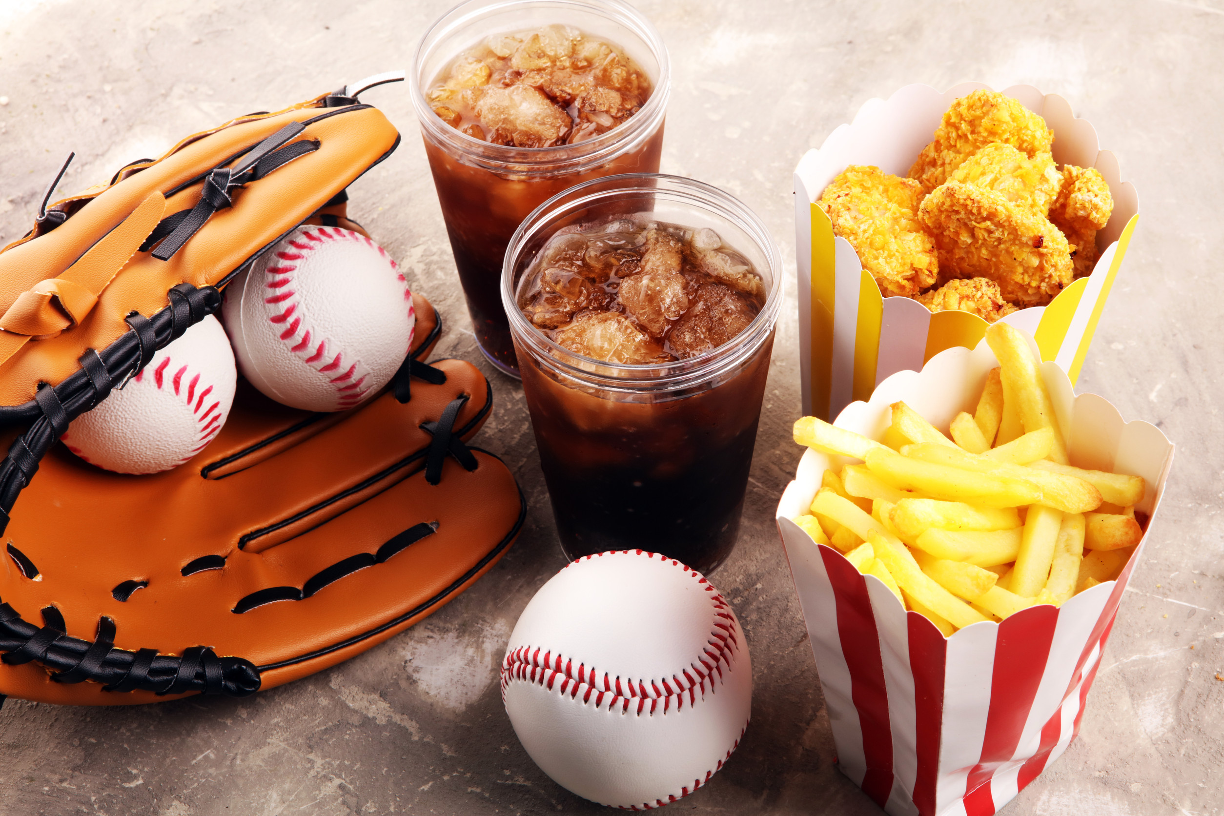 Chicken nuggets and french fries on the table with cola softdrink. Baseball party food