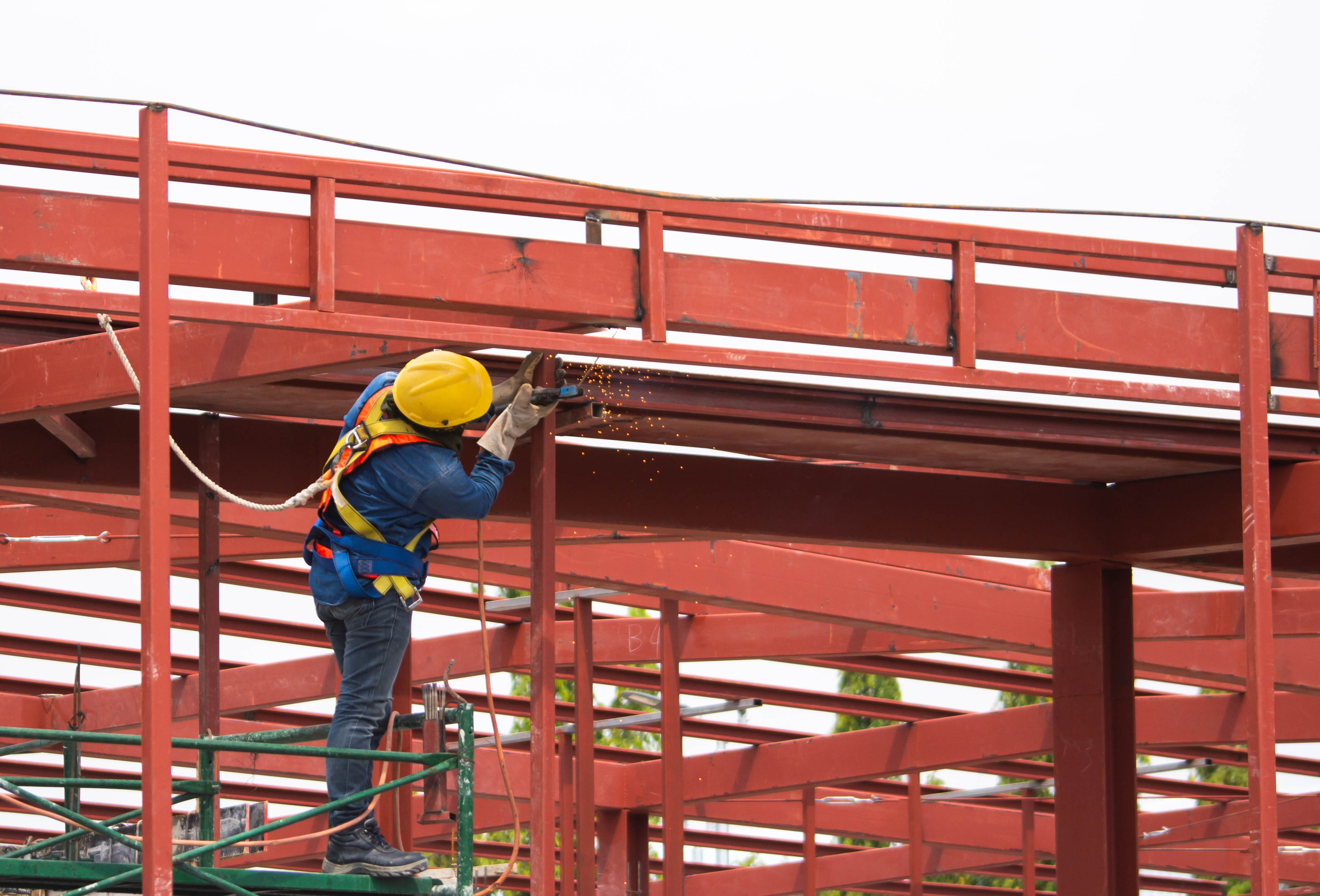 construction technician working on a large steel structure in fall protection gear