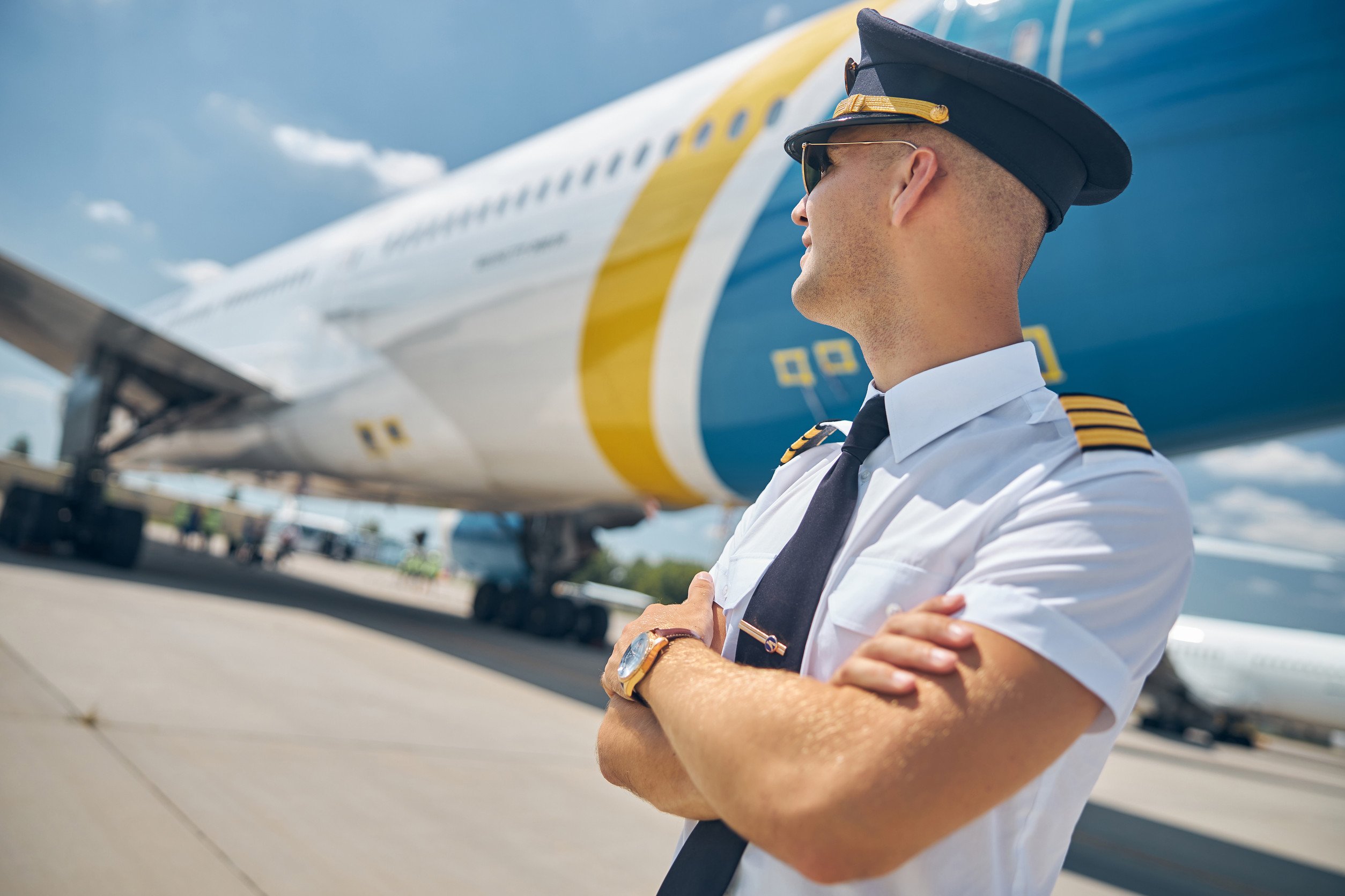 a pilot stands outside of a commercial airplane