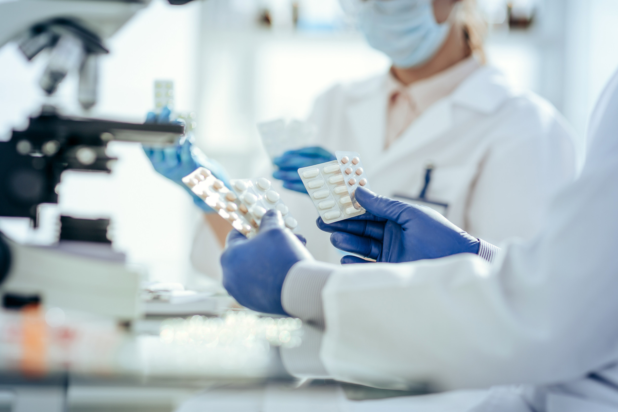 scientists with samples of new drugs sitting at a laboratory table