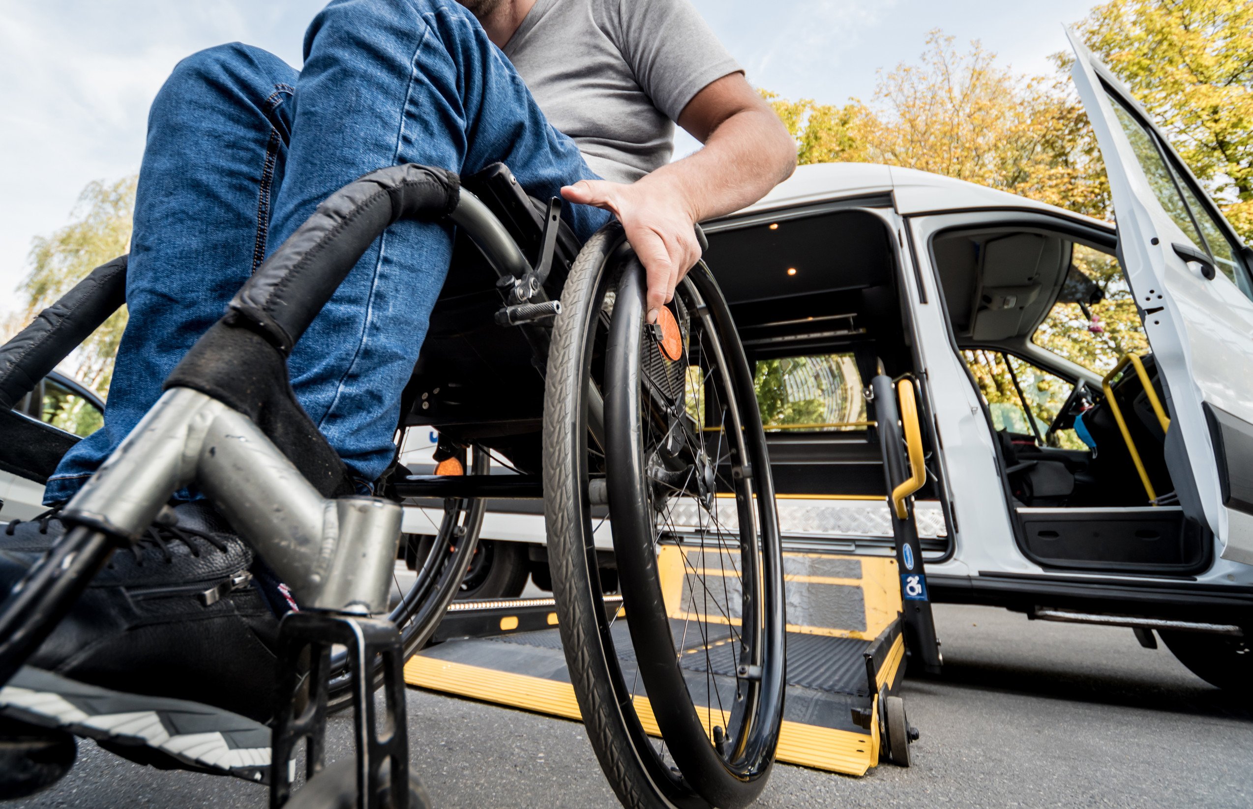 person in a wheelchair boards a specialized medical transport van
