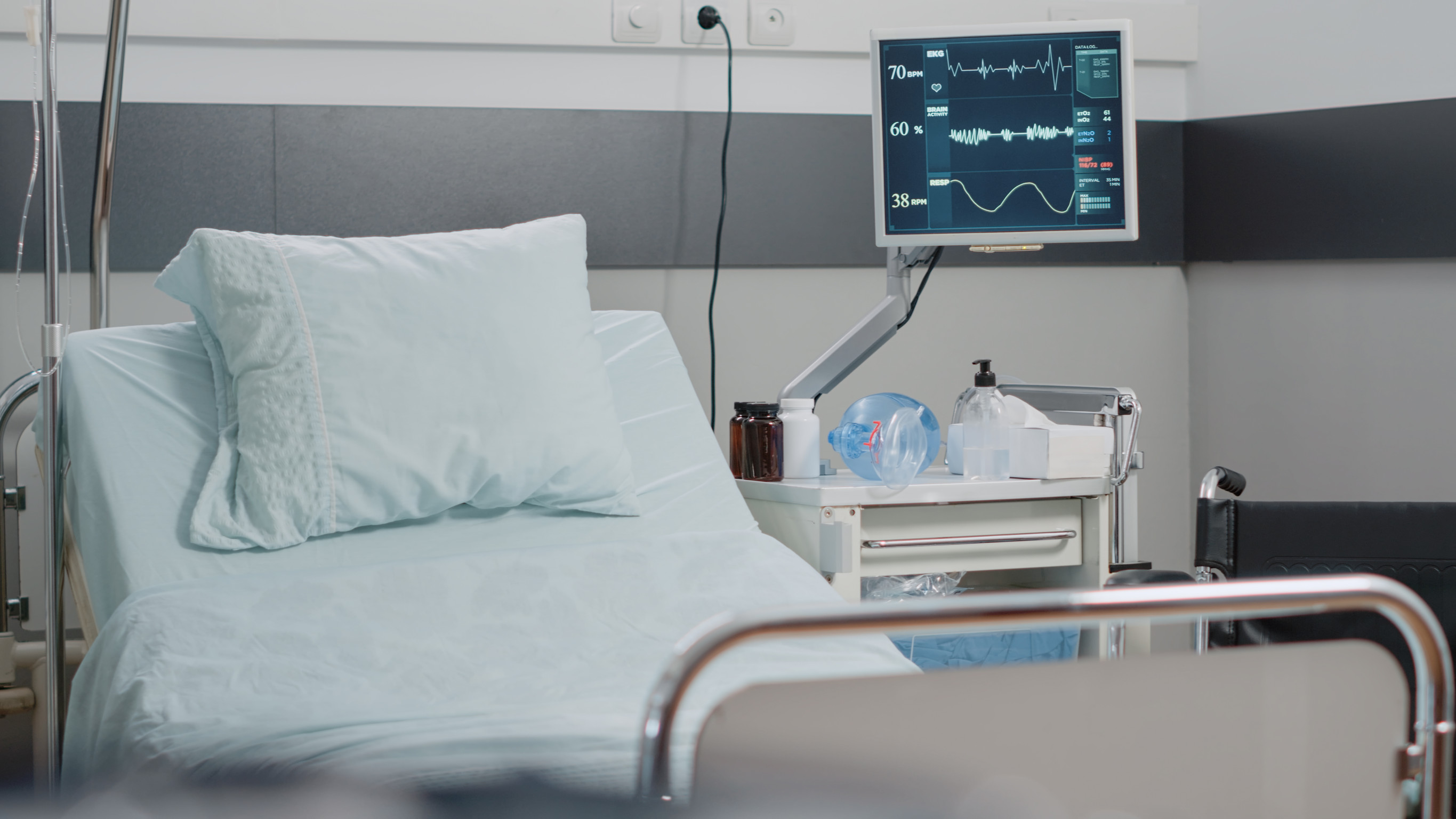 an empty hospital ward bed and medical machinery