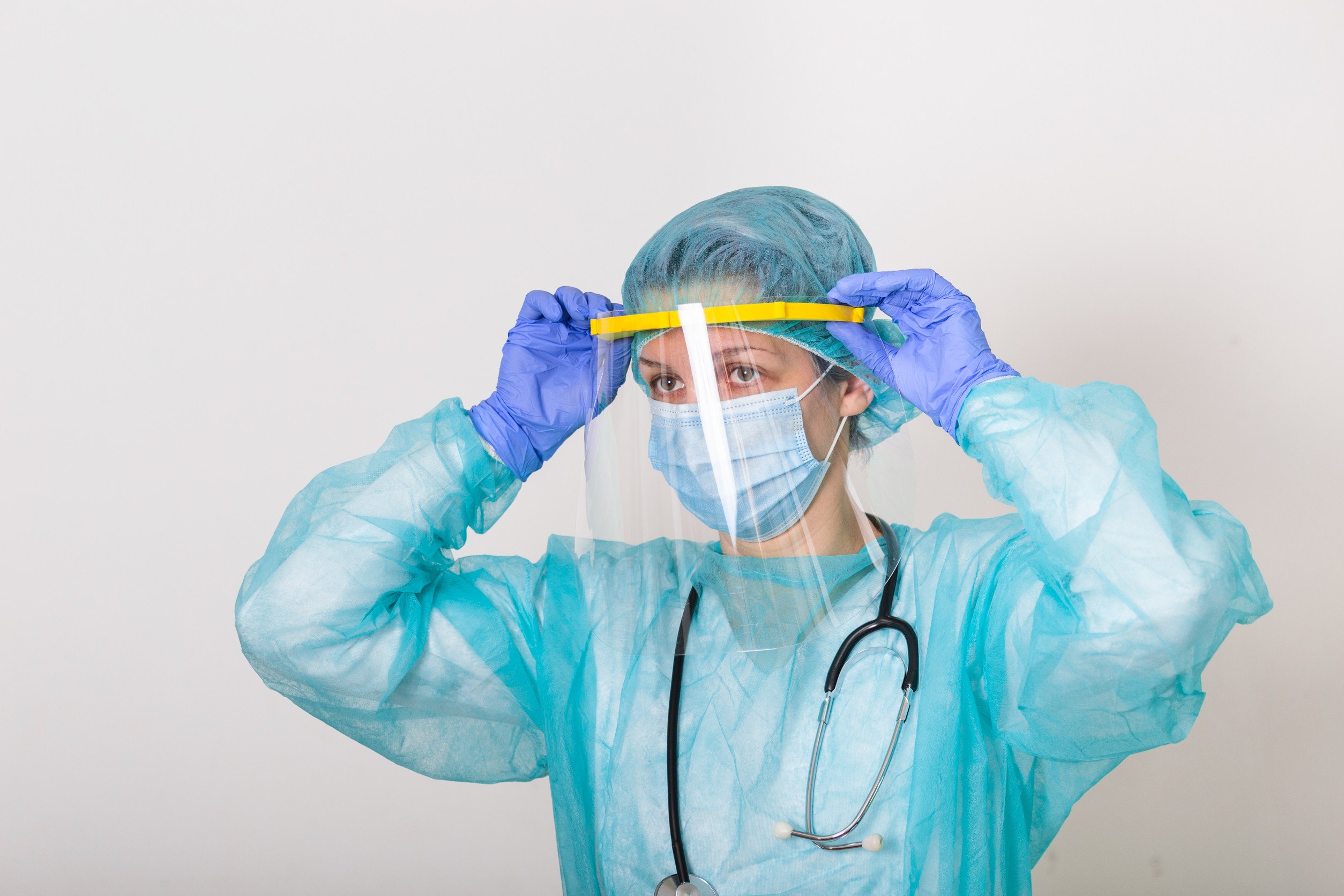 a healthcare professional donning personal protective equipment