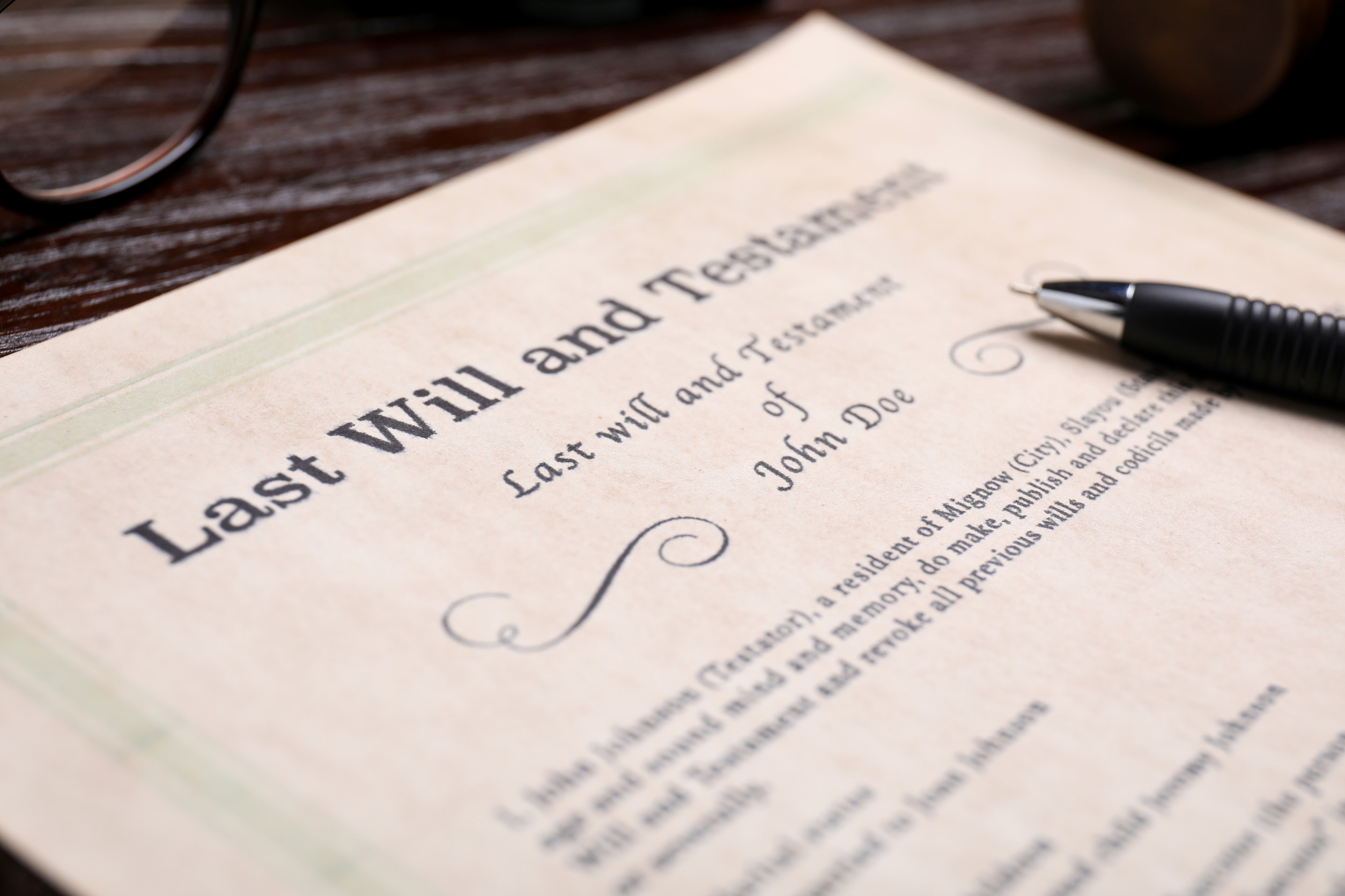 last will and testament document laid on table with a pen on top