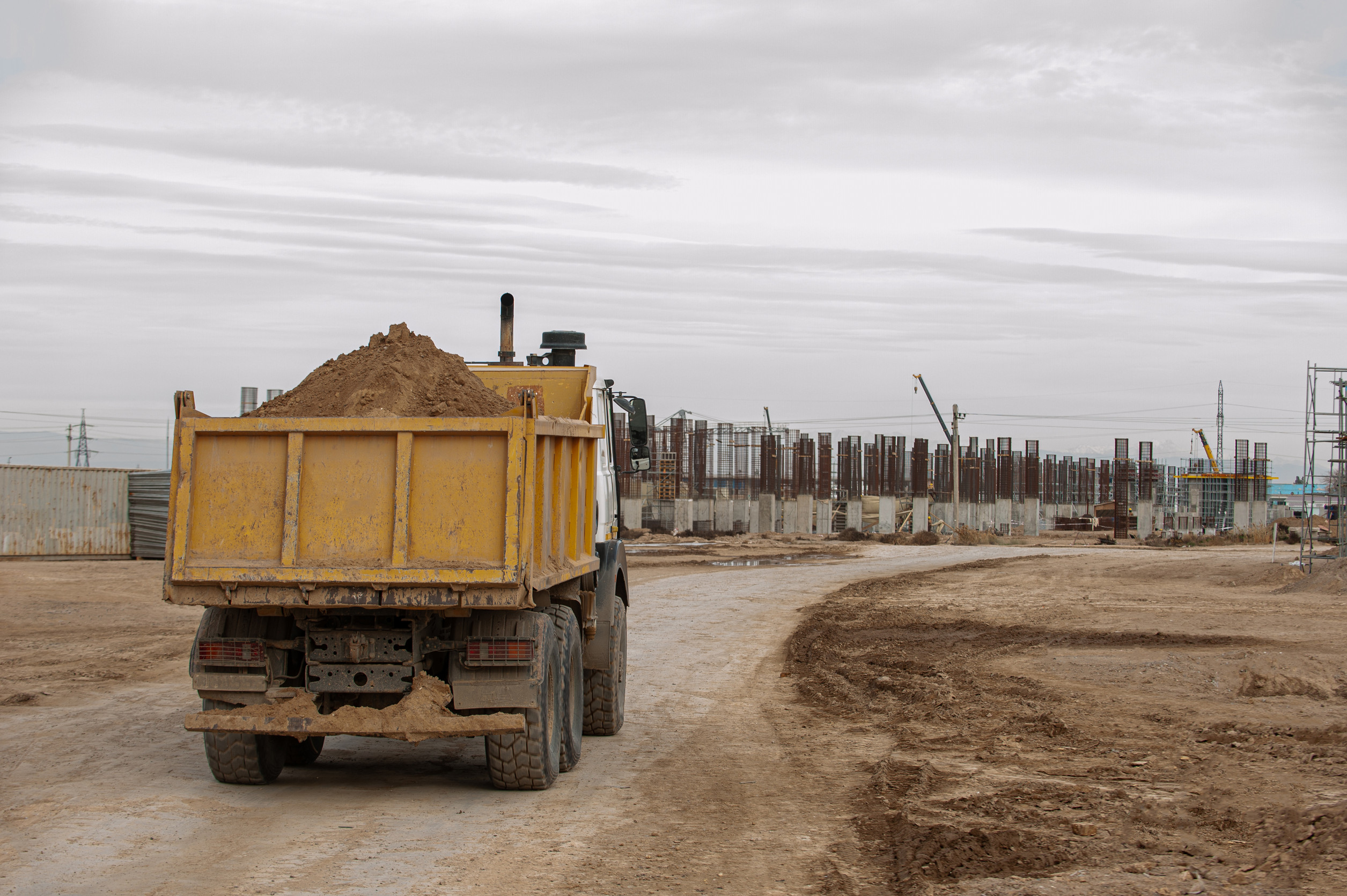 a dump truck hauls dirt near a construction site