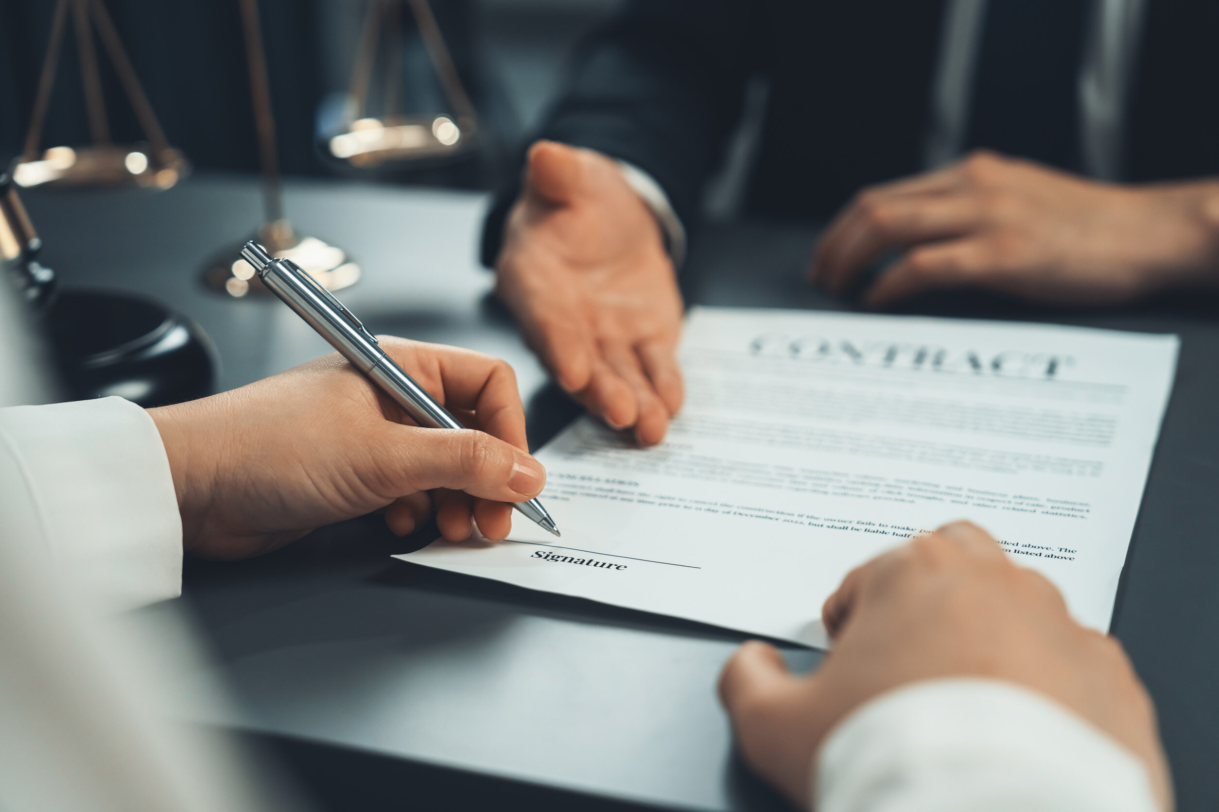 Closeup businessman sign contract or legal document with pen in his hand during corporate meeting for business deal or legal executive decision