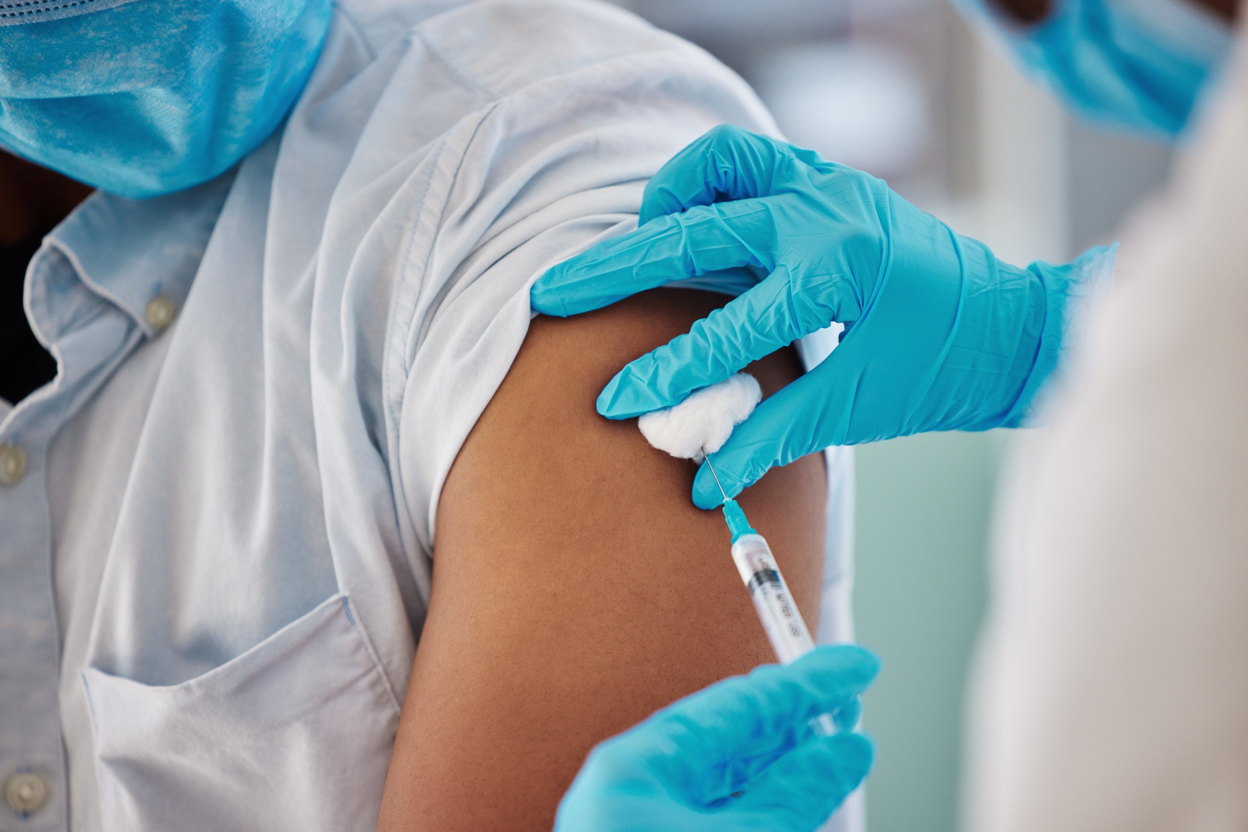 medical staff sticks a patient in the arm with a needle