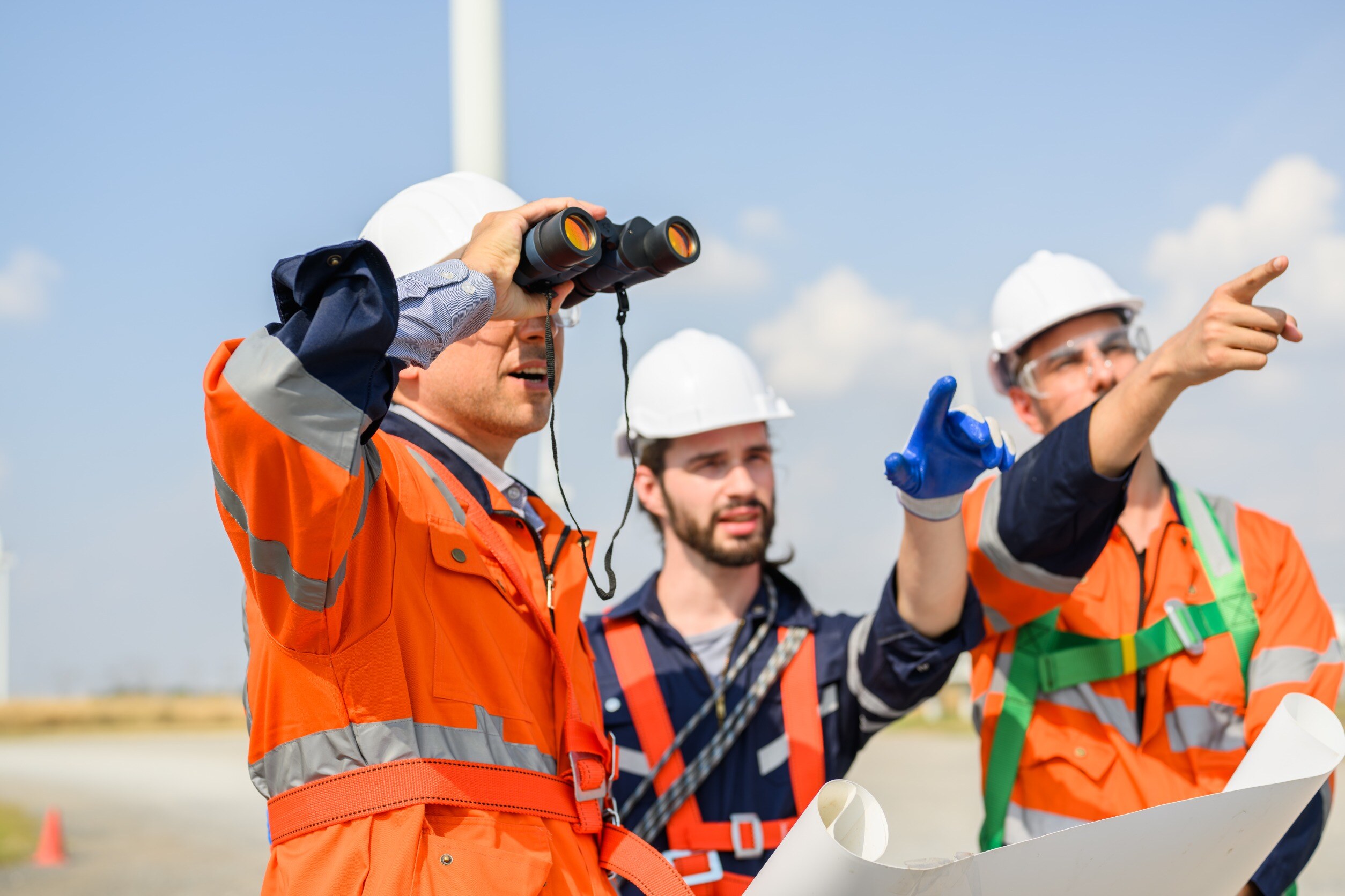 engineers and safety inspectors pointing and looking at something in the distance
