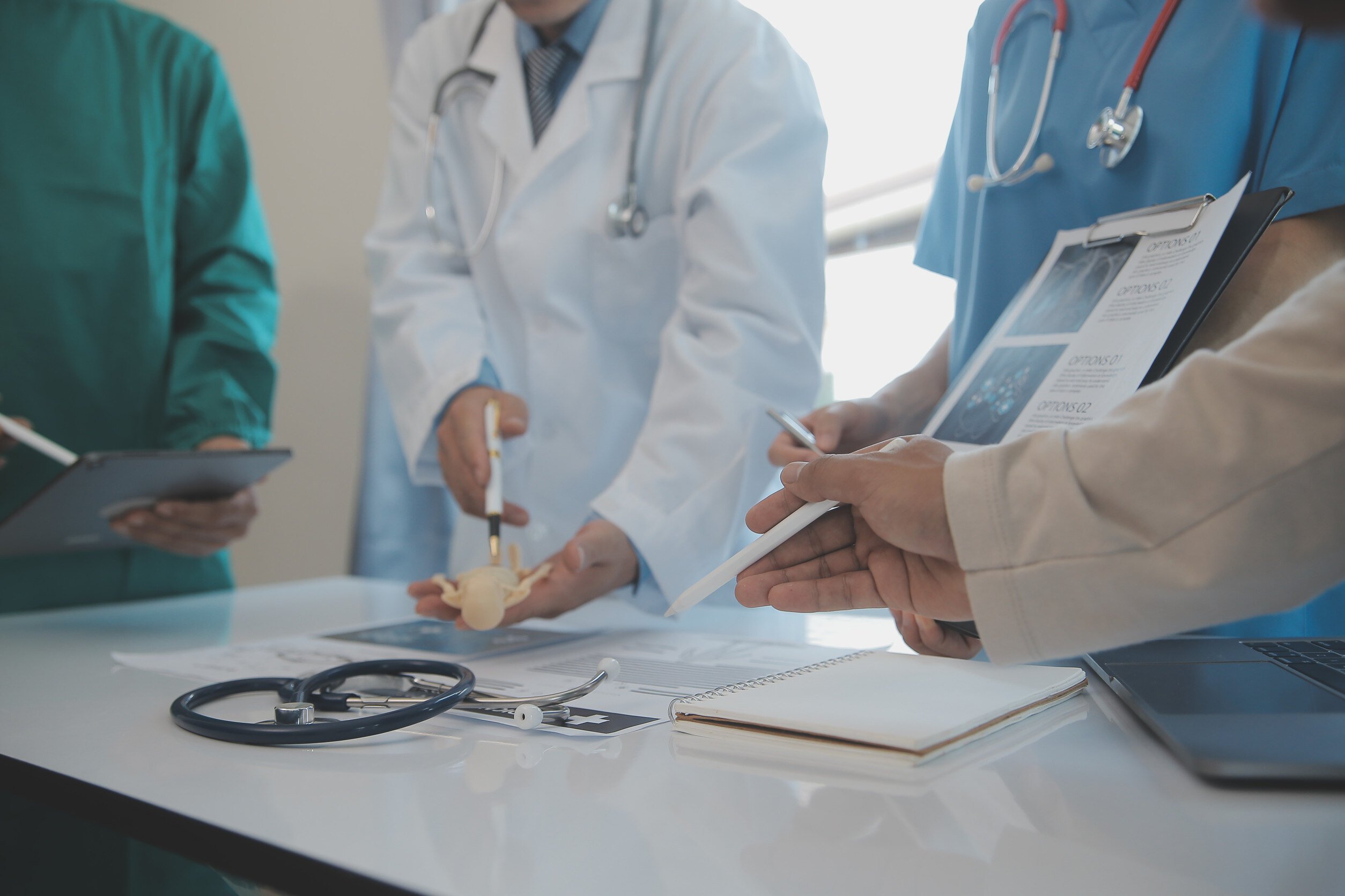 various medical staff having a discussion while holding different charts and tools