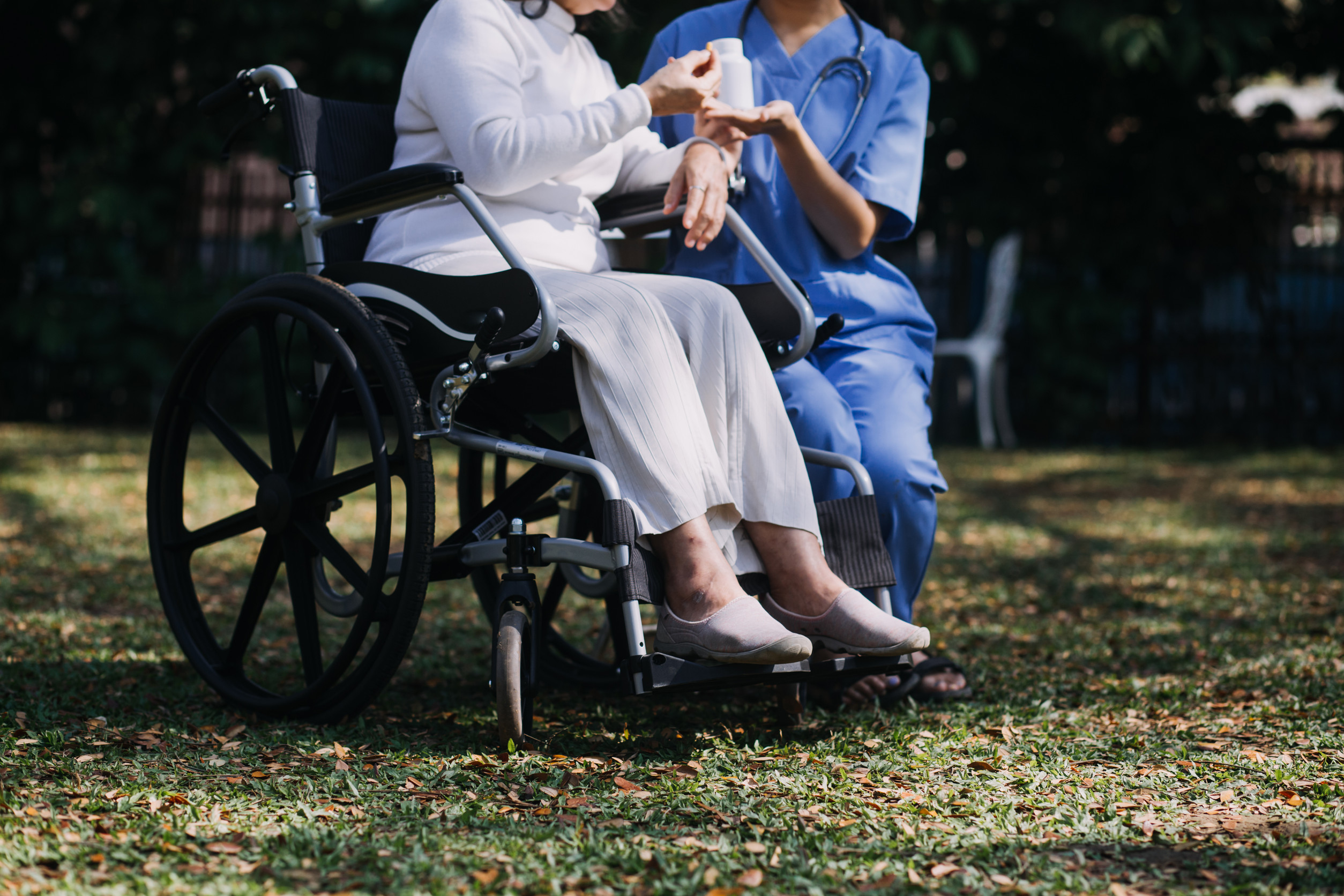 a nurse helps an elderly person in a wheelchair