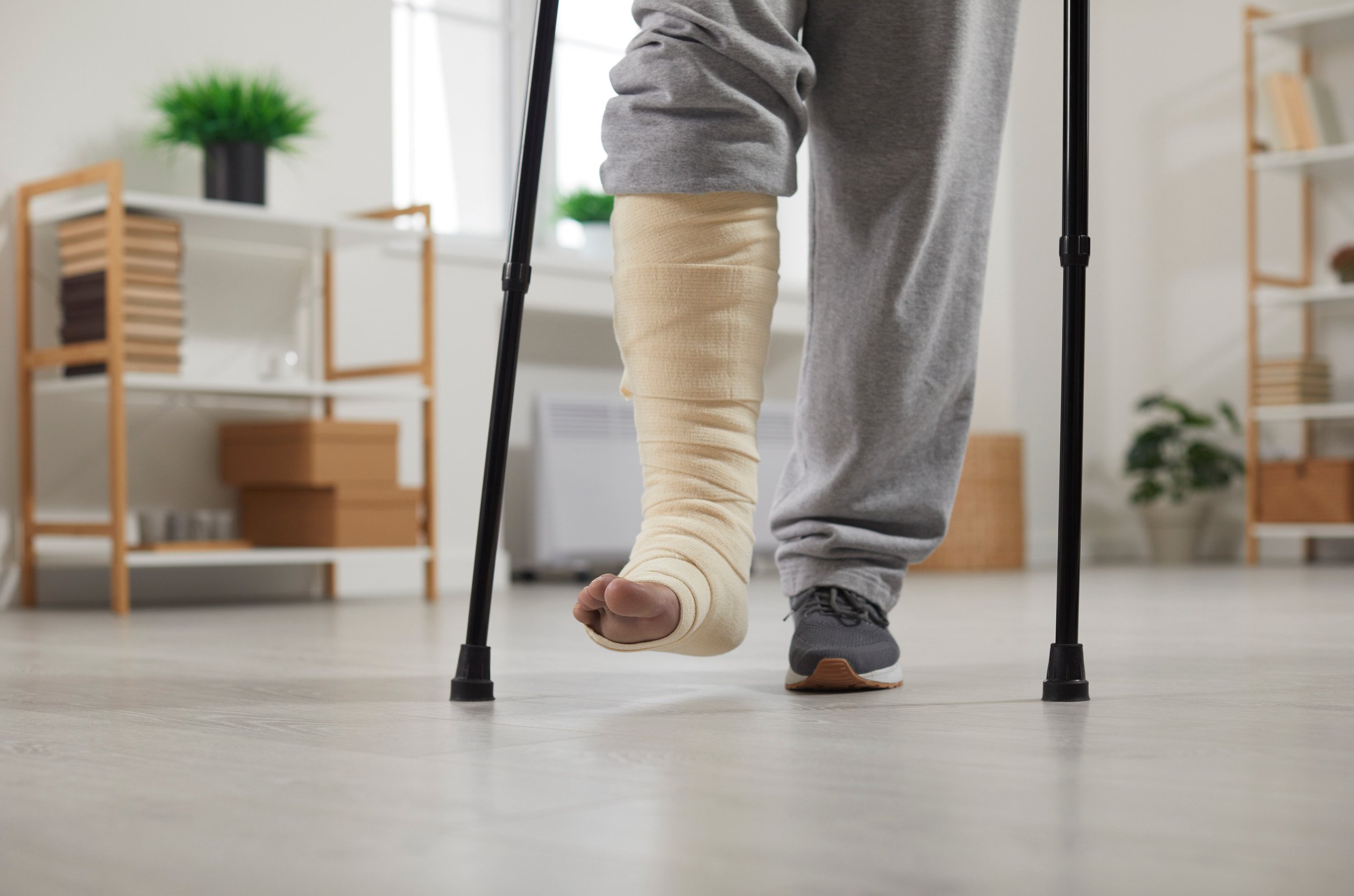 person walking with crutches and a cast on their right leg