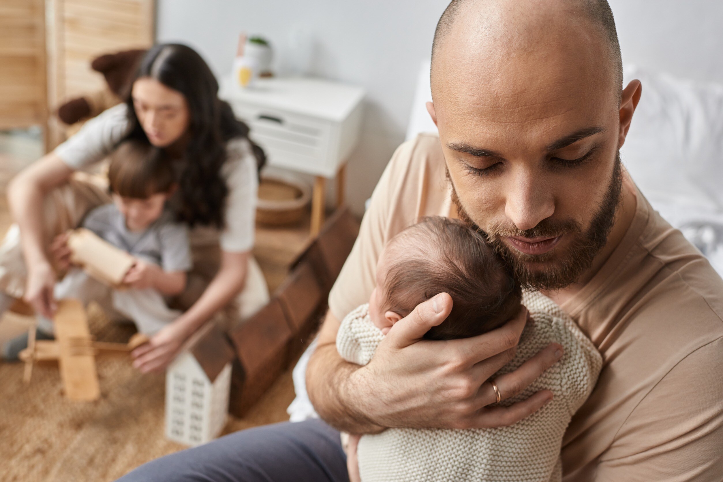 a mother and father caring for their infant and toddler children