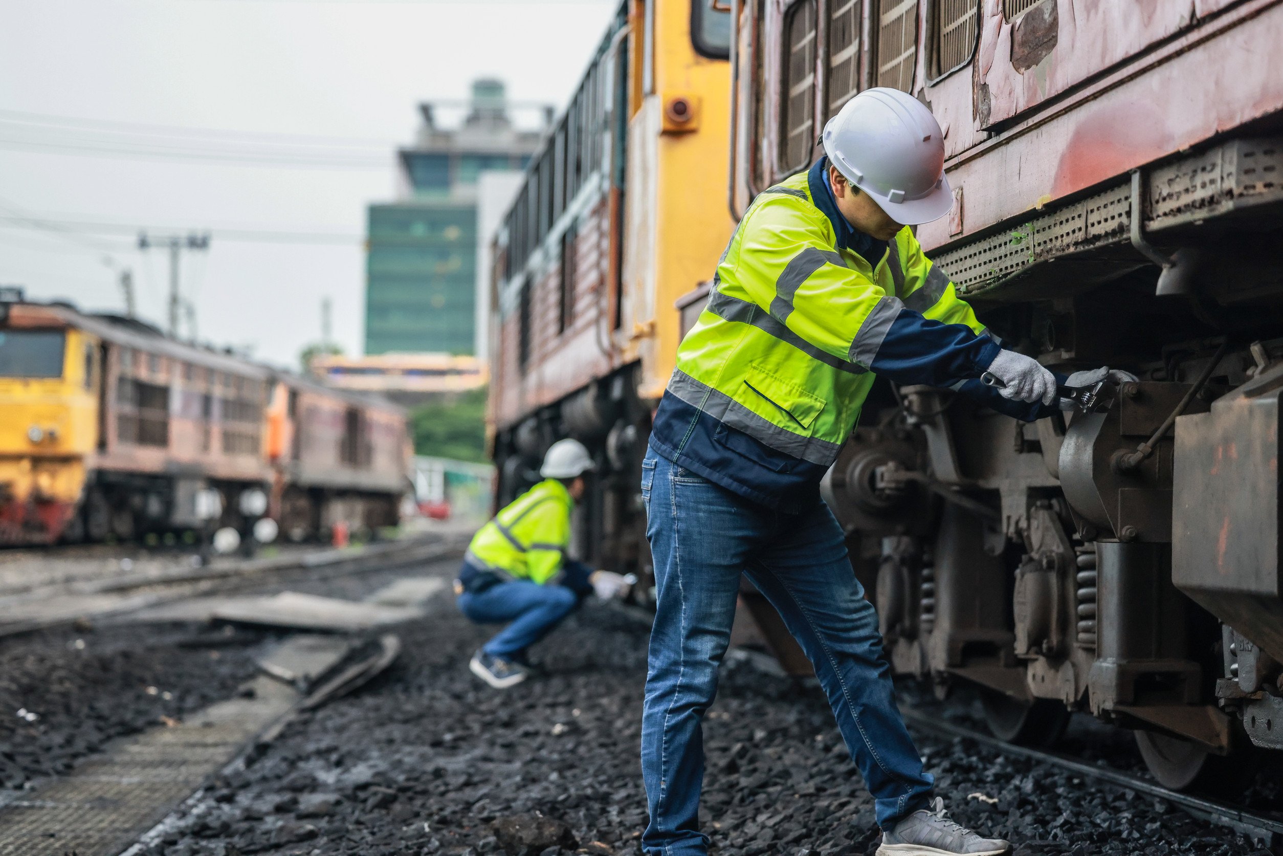 railway workers work on trains in a train yard