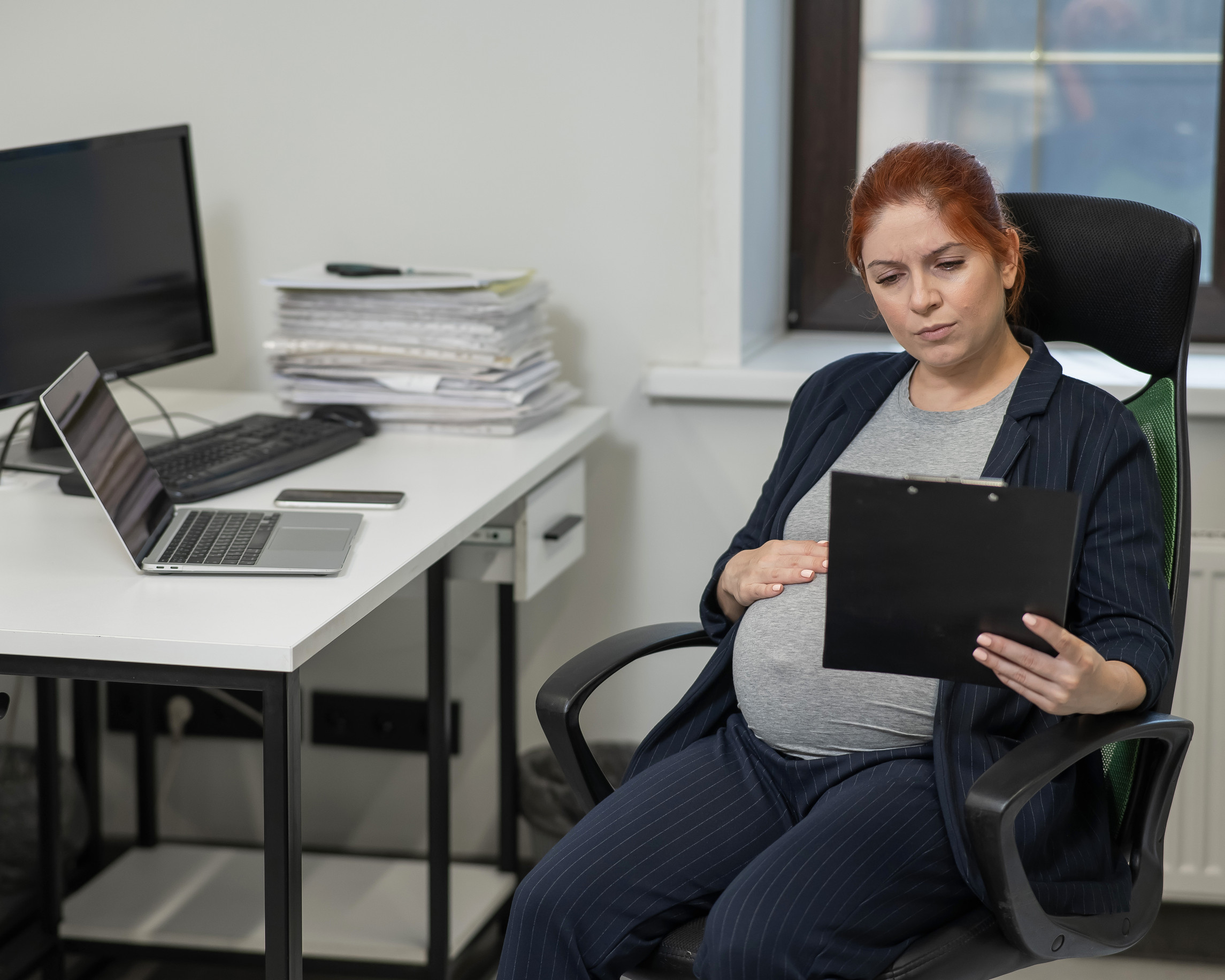 pregant woman sitting at her desk at work