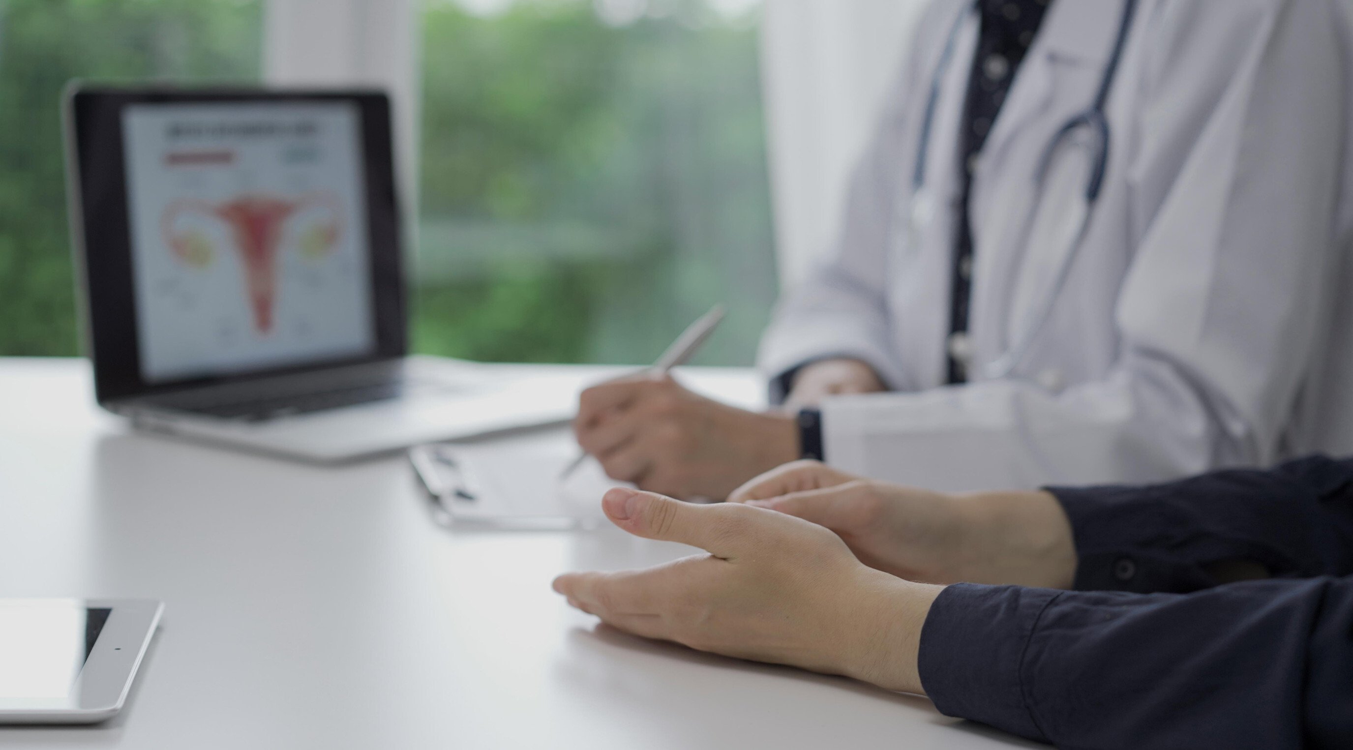 an OBGYN consults with her patient at her computer