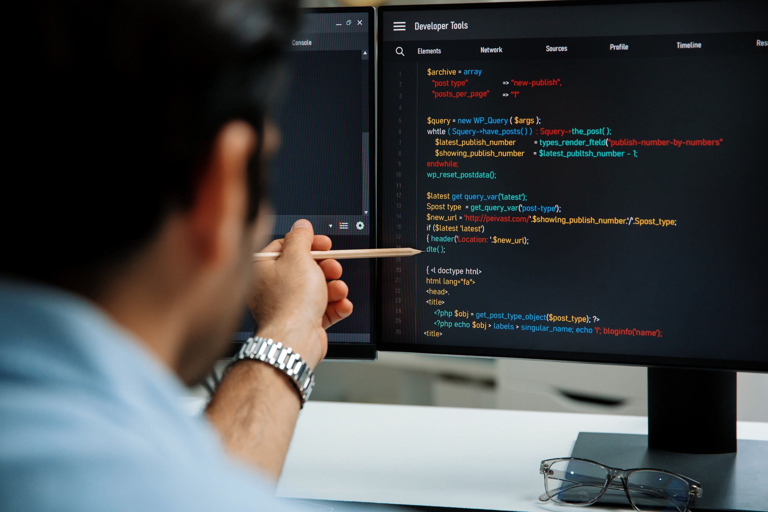 software engineer examining source code on a computer monitor in a professional setting