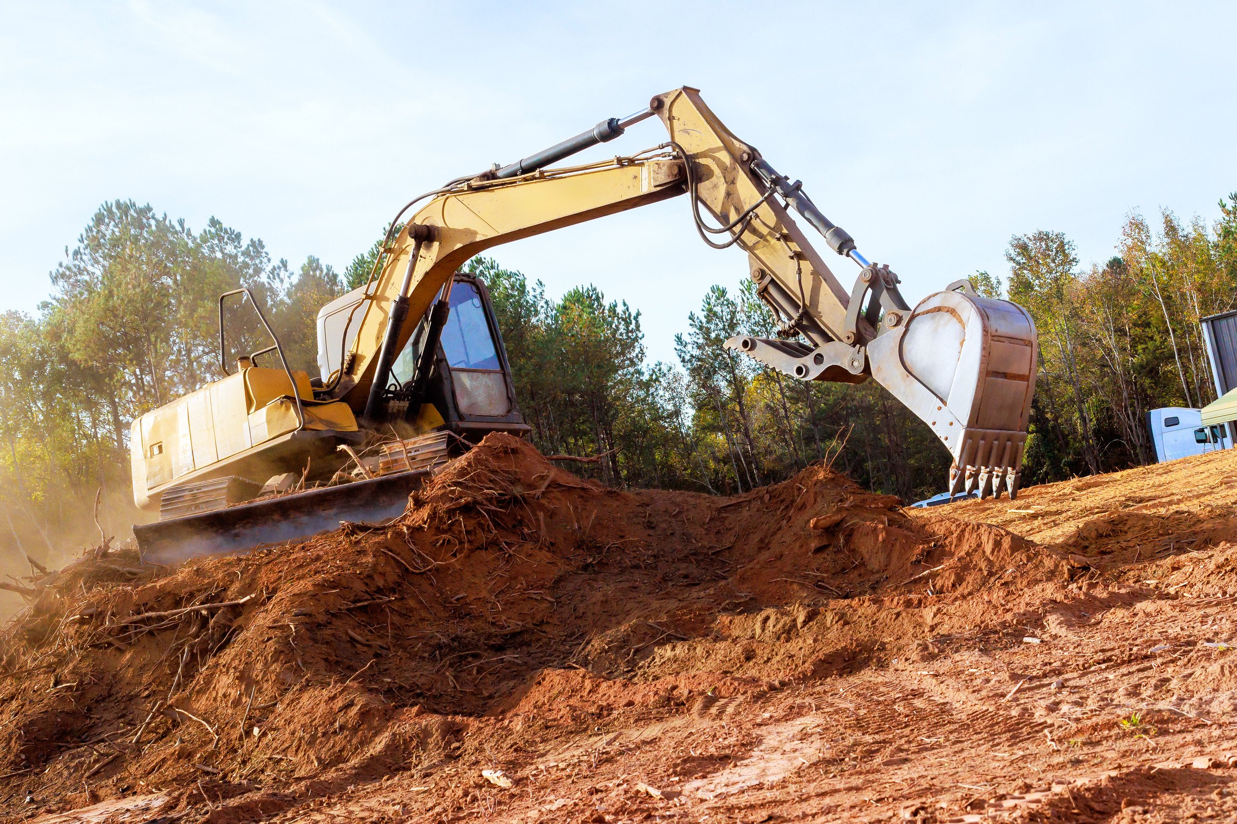 a large excavator moves large quantities of dirt