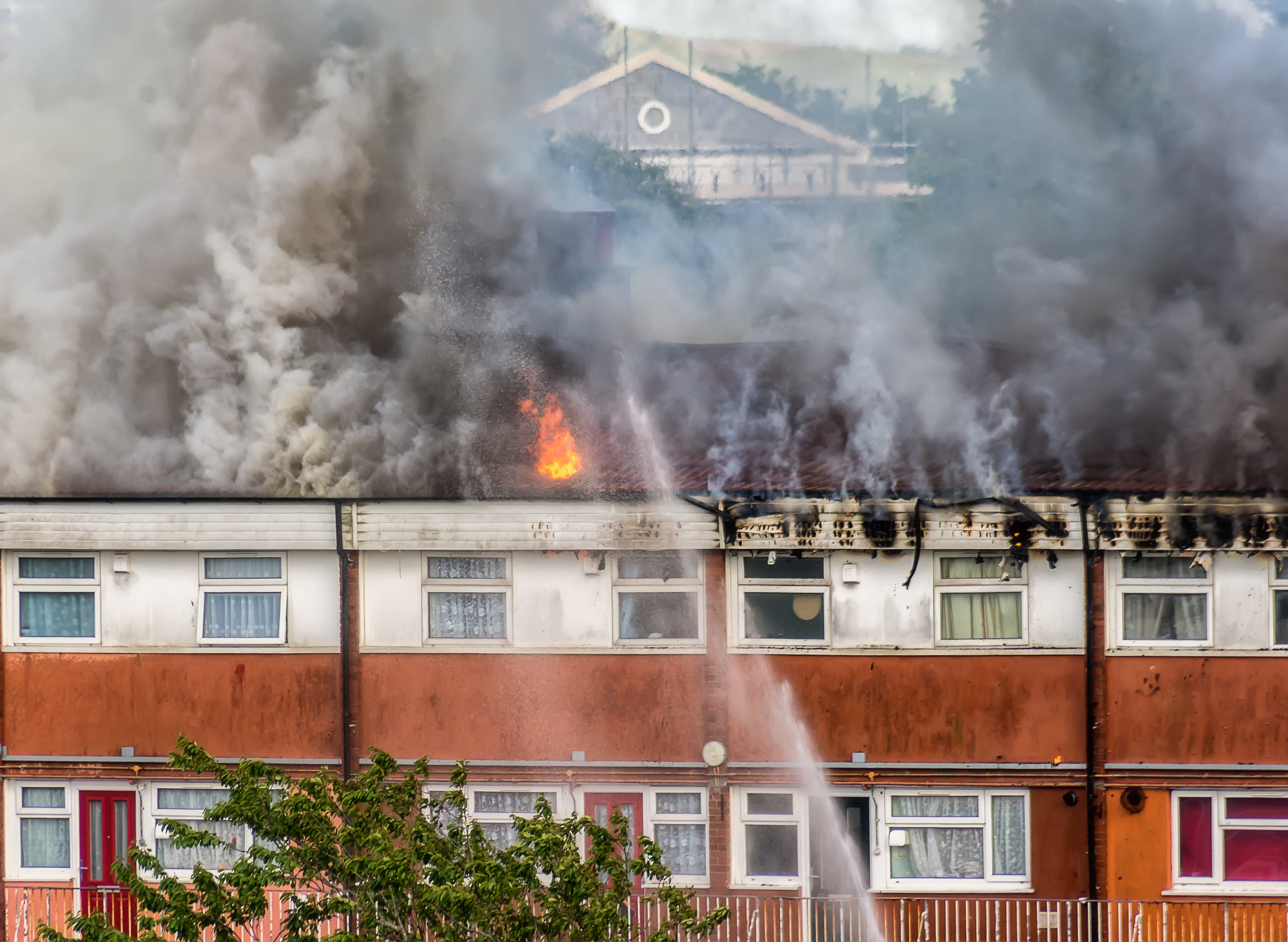 townhouse apartments on fire being sprayed with water
