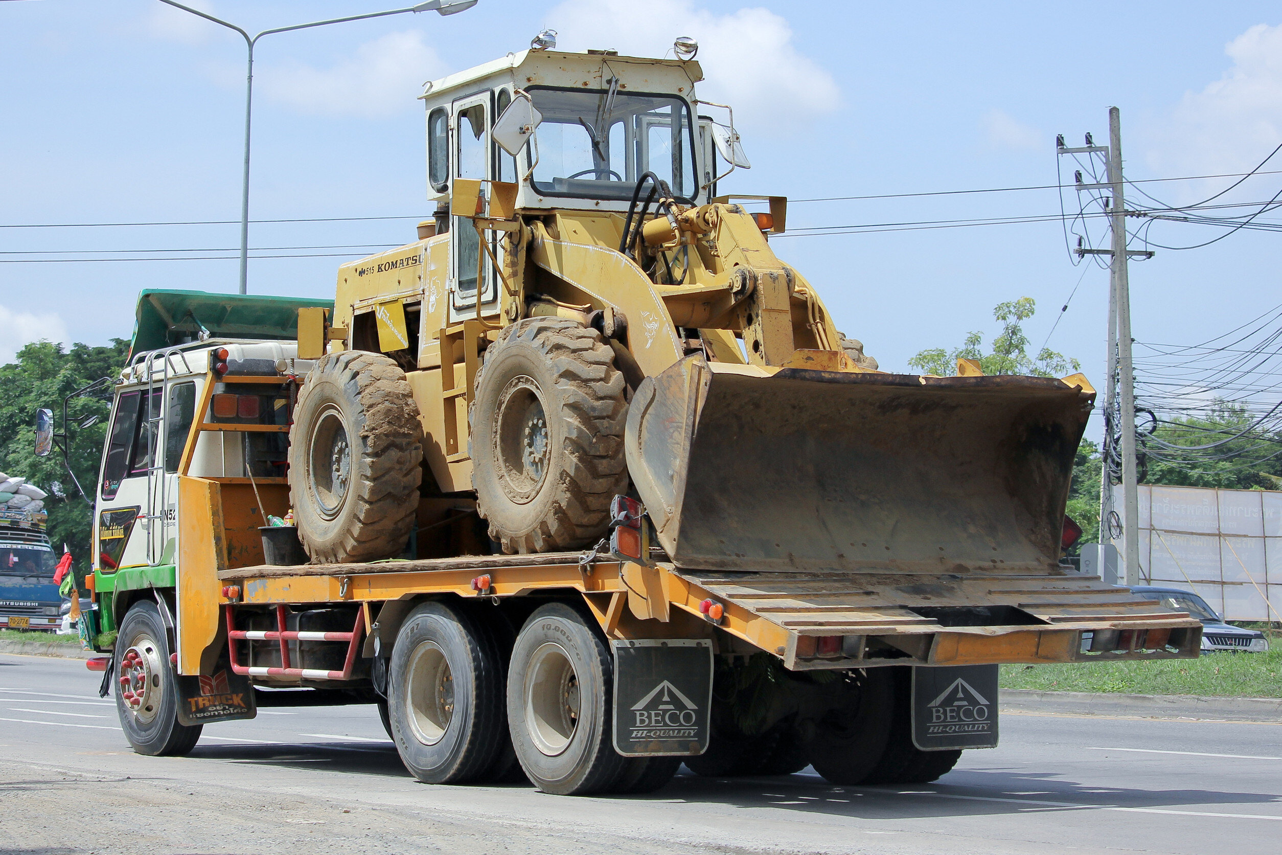 a flatbed truck transports a buldozer