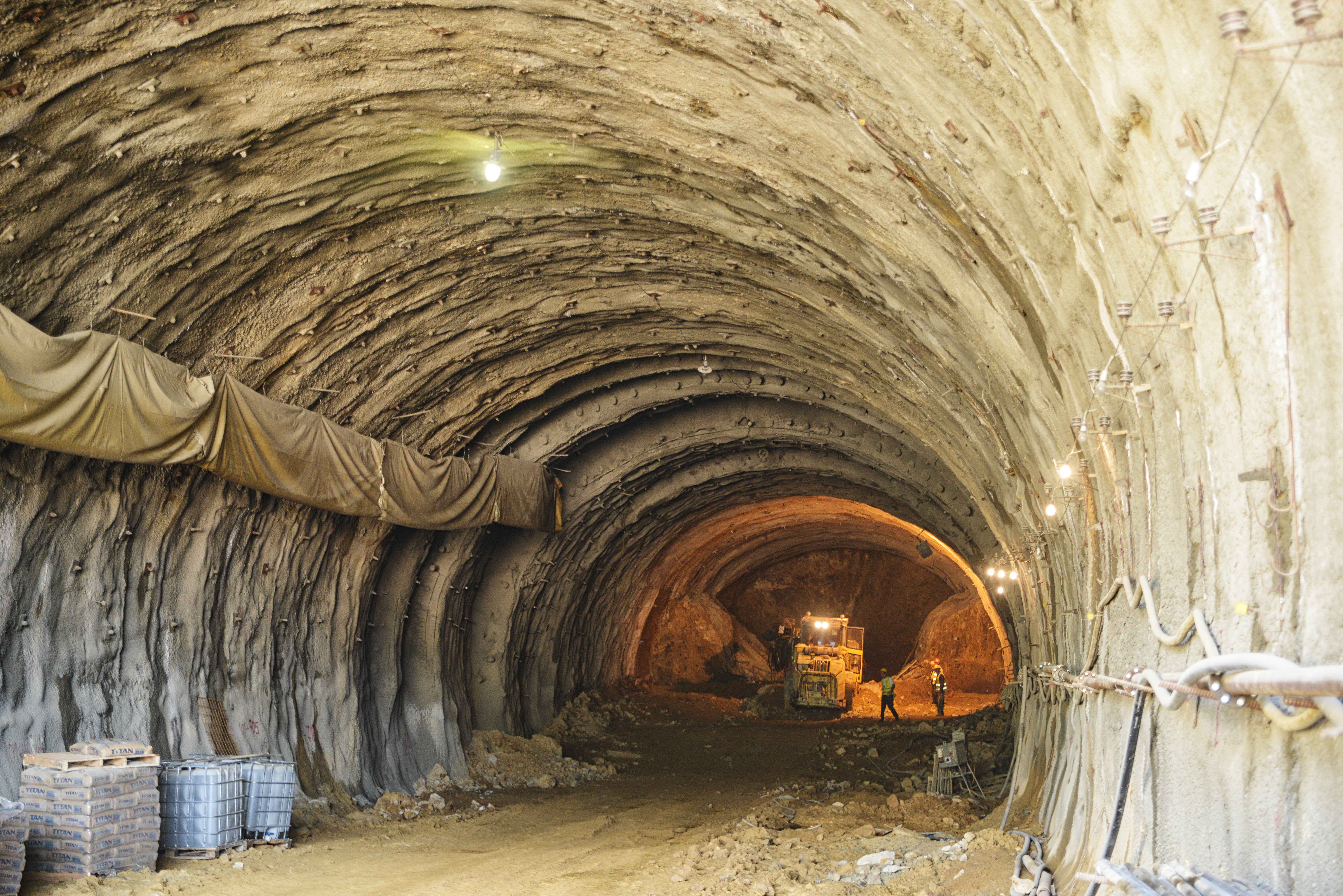 construction workers at the end of a tunnel that is under construction