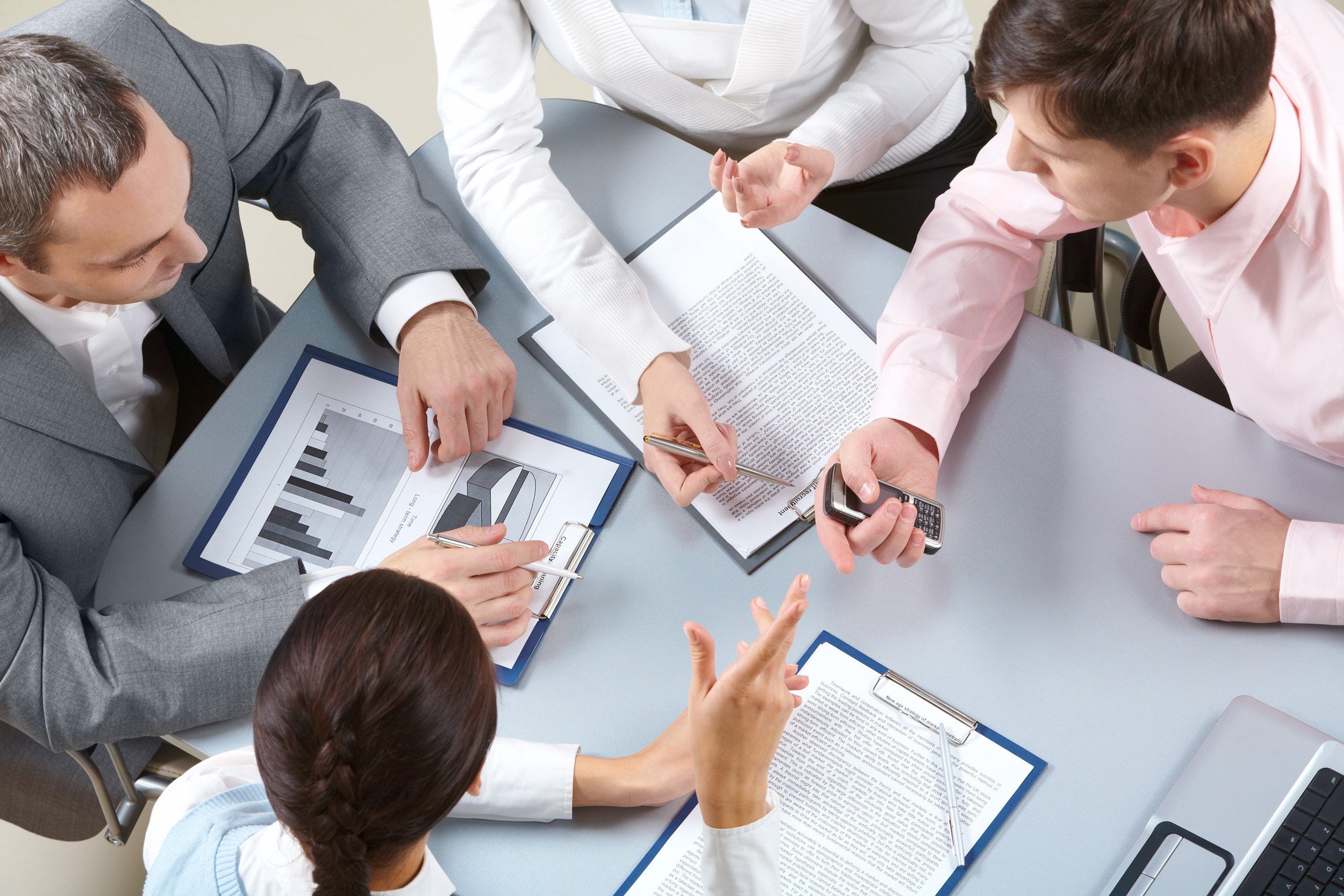 High angle view of business people sitting at table and discussing financial documents