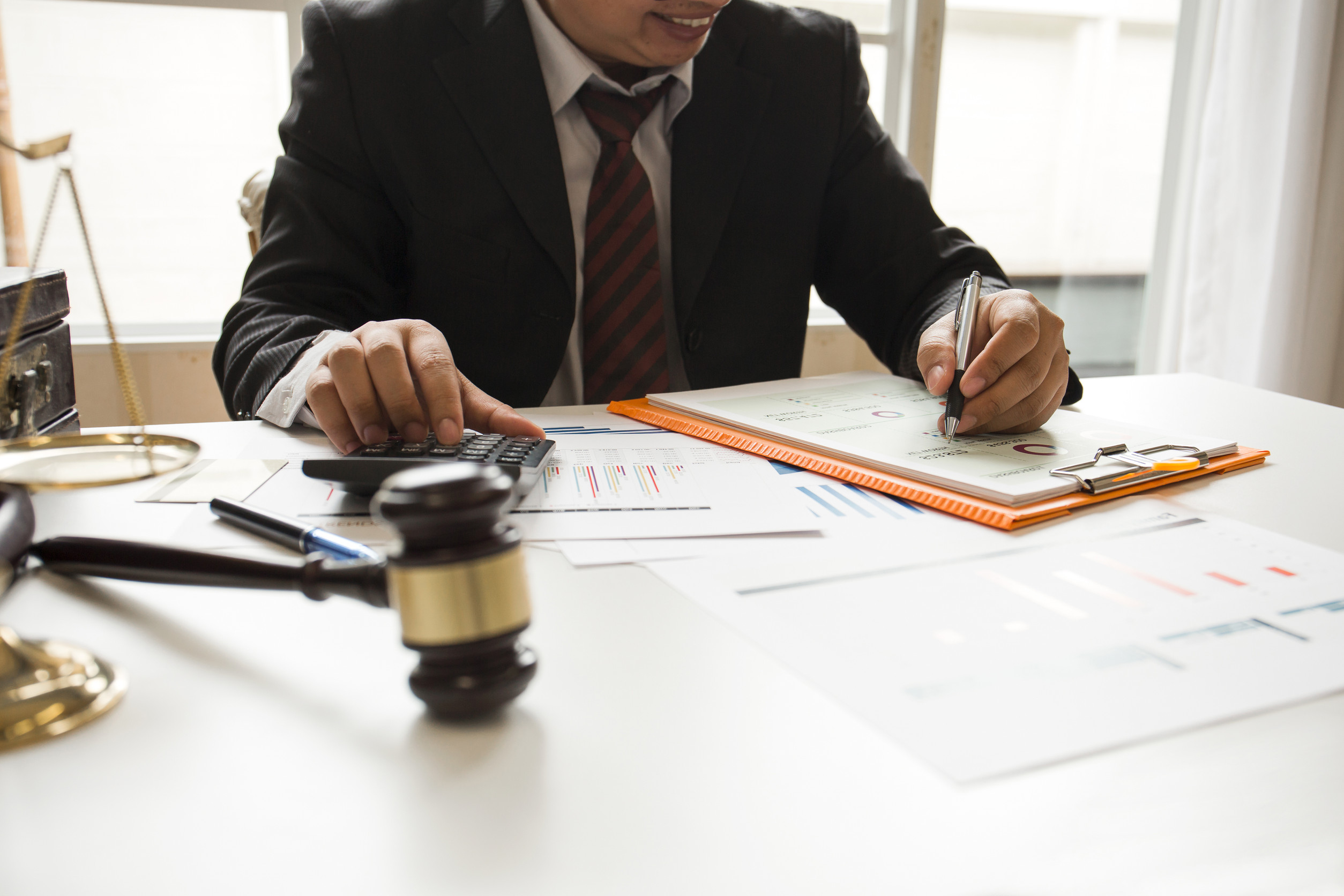 lawyer working in his office with a gavel and clipboard on his desk