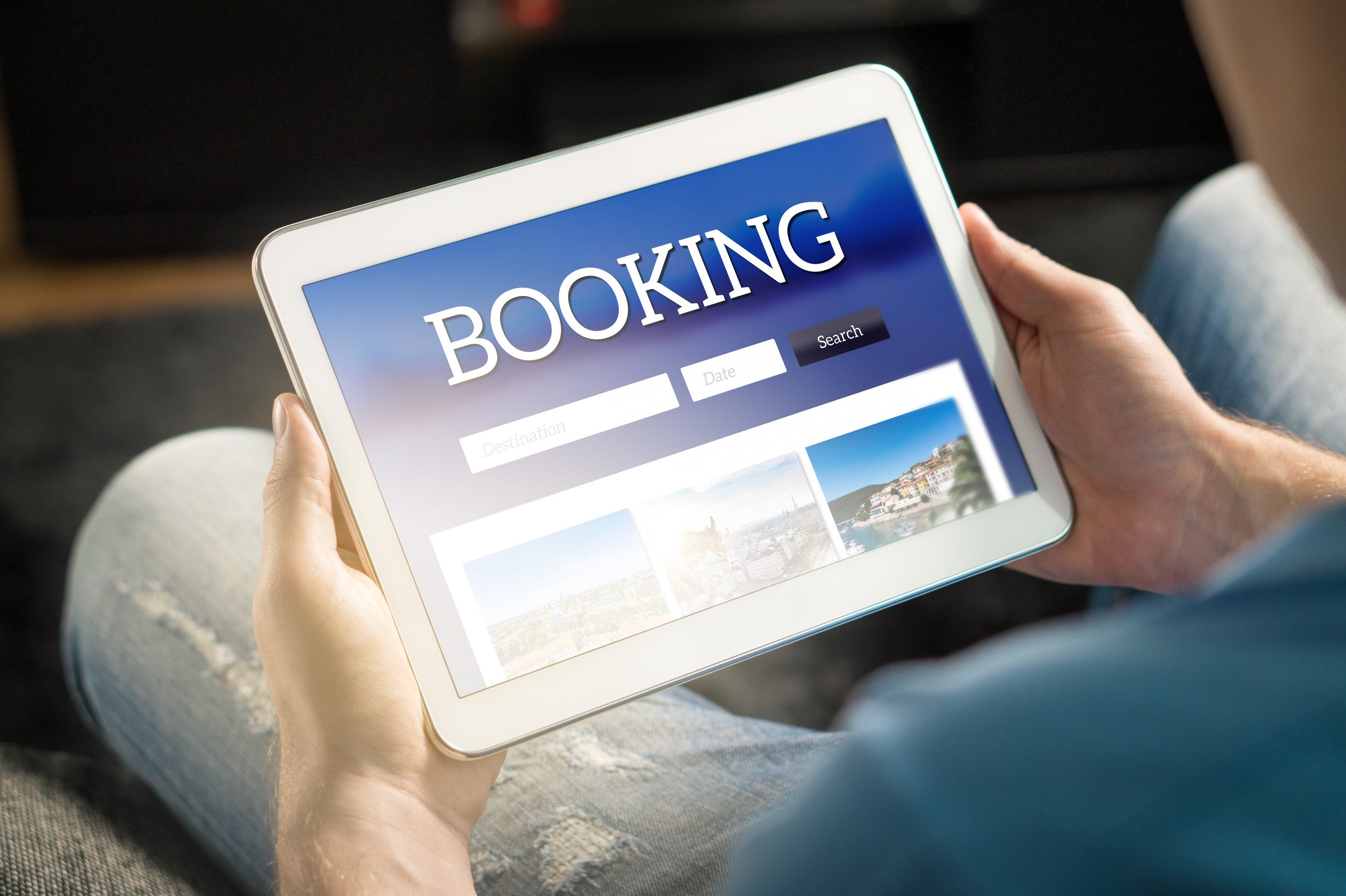 image of website for booking accomodations displayed on an ipad held in someone's hands