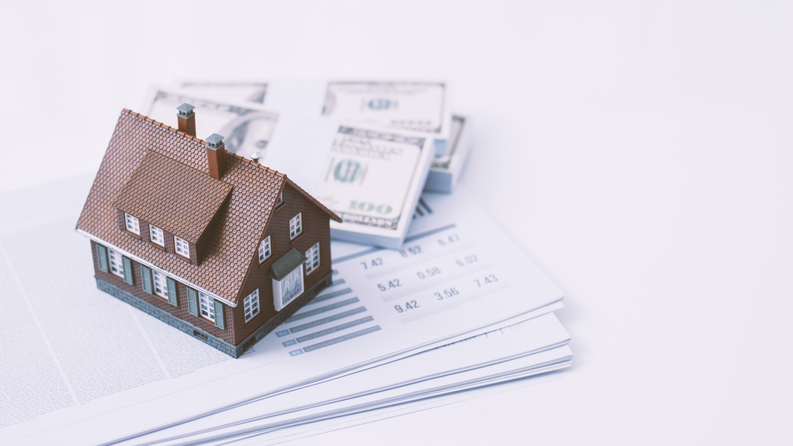 House model and dollar banknotes on white background