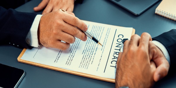 closeup-hand-signing-contract-document-with-pen-sealing-business-deal