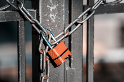 a chain and padlock hold a metal gate shut