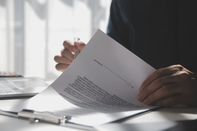 Person looking through a contract that's on a clipboard