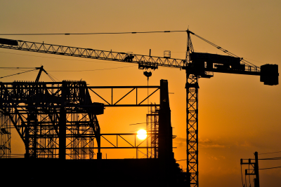 Silhouette of construction site against sunset 