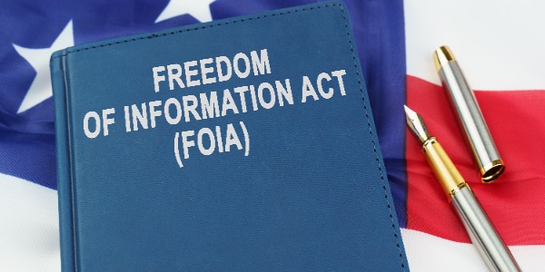 law-concept-on-the-us-flag-lies-a-pen-and-a-book-with-the-inscription-freedom-of-information-act