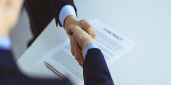 business-people-shaking-hands-while-sitting-at-the-desk-at-meeting