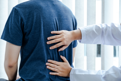 a medical professional places both hands on the back of a patient