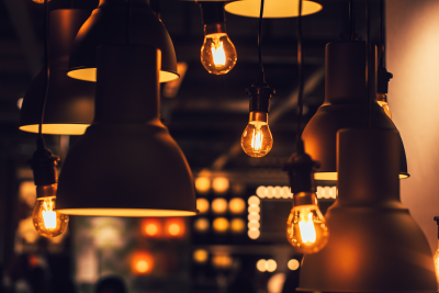 Picture of several different overhead lamps turned on at night.