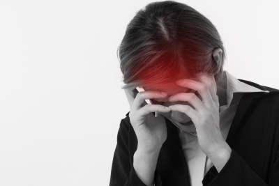 a woman holds her head in pain