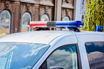 Picture of the top of a police car, focusing on the red and blue sirens.