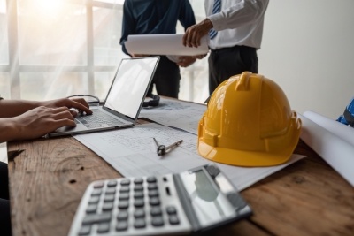 Team of construction workers reviewing documents over a desk.