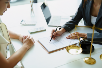 two people sit at a desk reviewing the details of a contract
