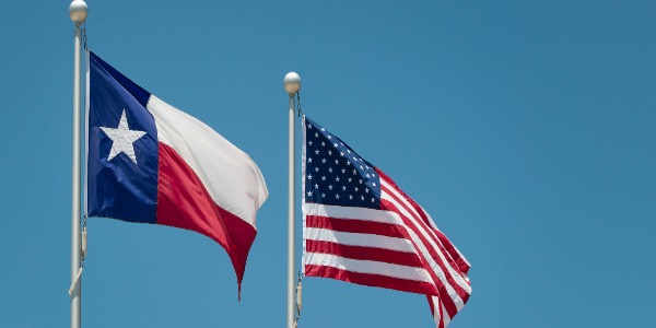 the-state-flag-of-texas-and-american-flag-waving-in-the-wind-on-flagpole