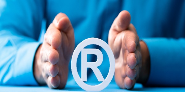 man-with-hands-on-either-side-of-a-registered-trademark-symbol