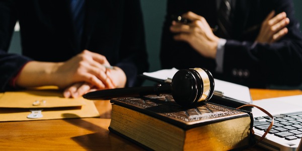 business-and-lawyers-discussing-contract-papers-with-brass-scale-on-desk-in-office-law