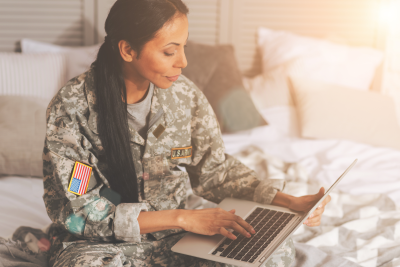 an american soldier in uniform working on a laptop computer