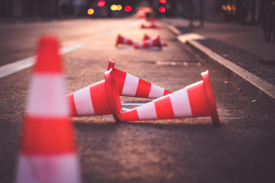 traffic cones toppled over and scattered in the middle of the street