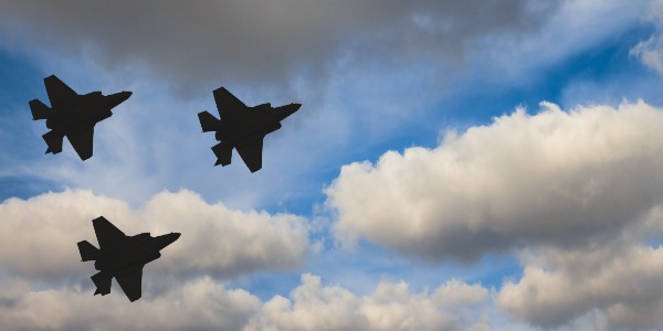 silhouettes-of-three-f-35-aircraft-against-the-blue-sky-and-white-clouds