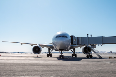 Front view of a white passenger airplane at the boarding bridge